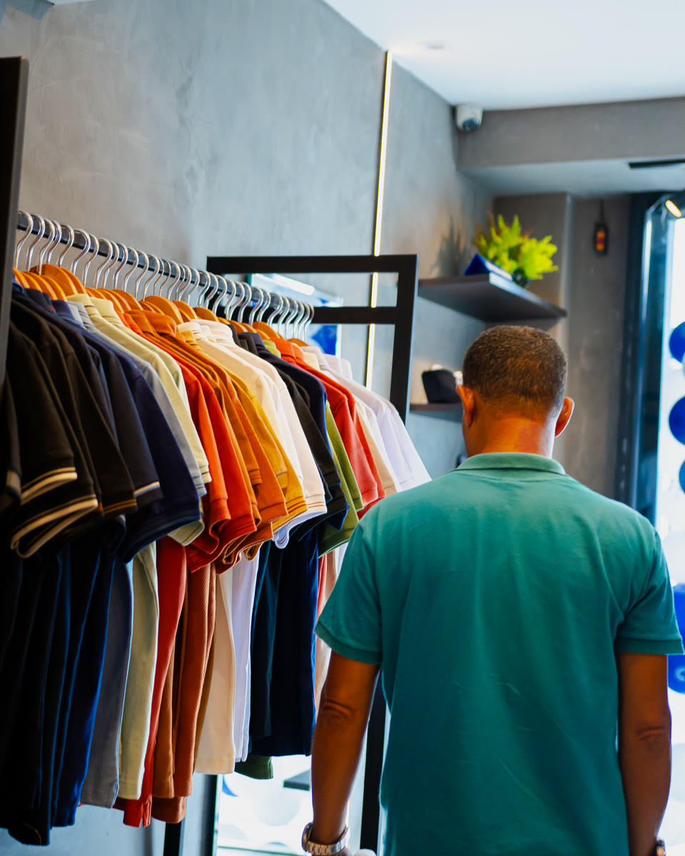 Cliente escolhendo peças na arara da Ópera Men